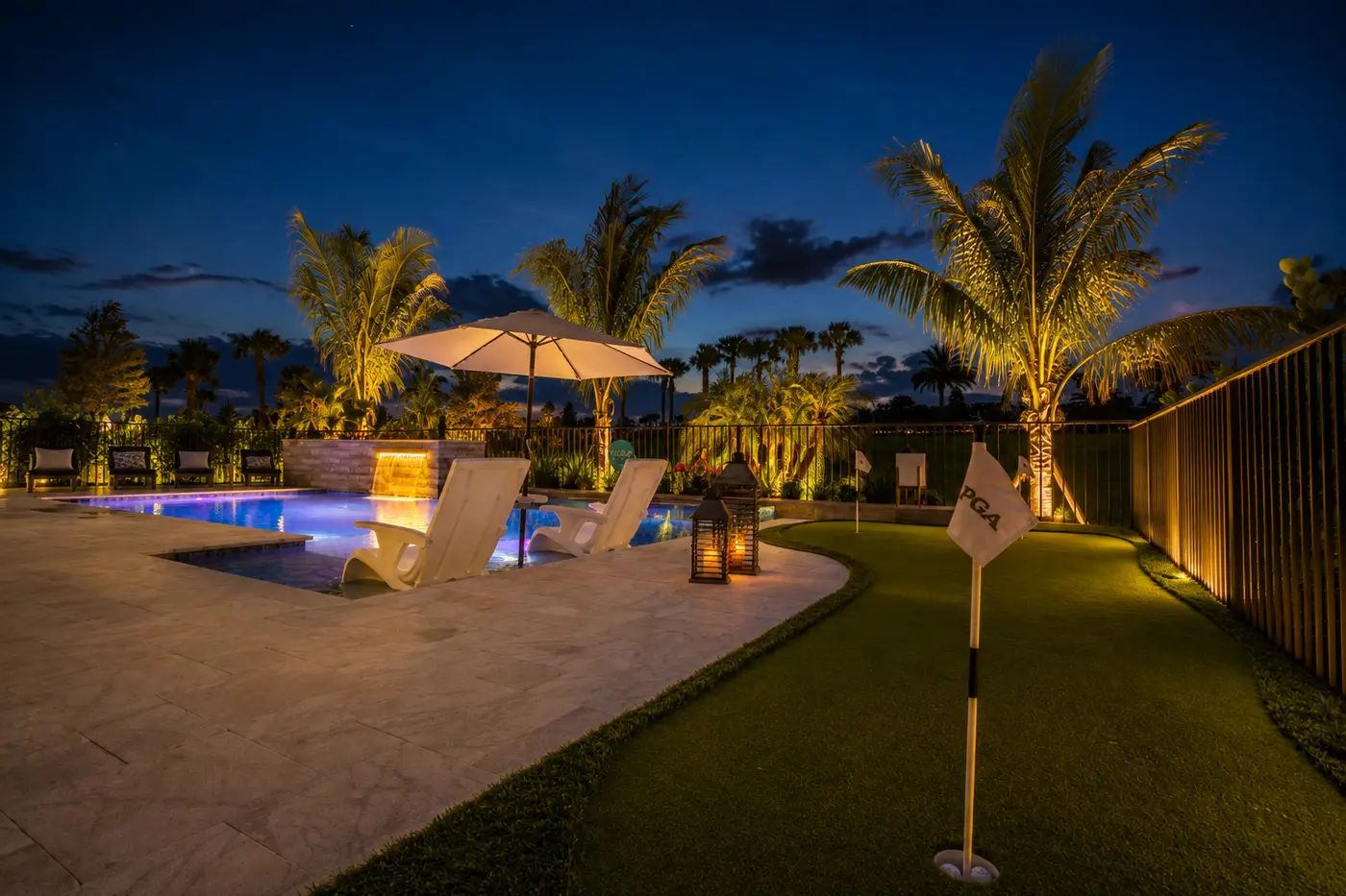 Pool with putting green and lantern-lit deck in Stuart